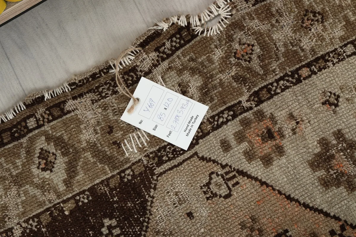 Close-up of the rug with its product tag, displaying size and origin information.