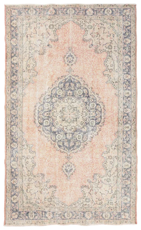 Full overhead view of the rose and navy medallion vintage Anatolian area rug on a white background.