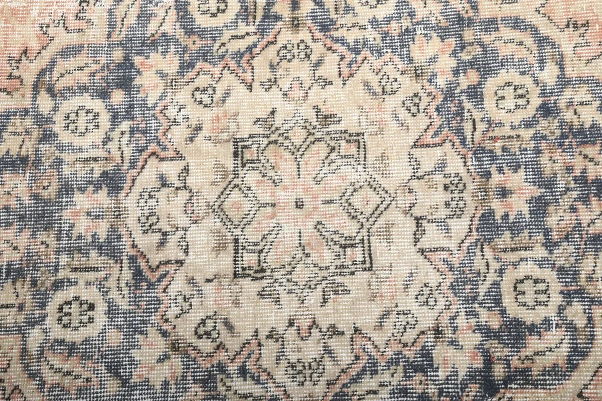 Macro detail of the central medallion's intricate beige and rose patterns within the navy.