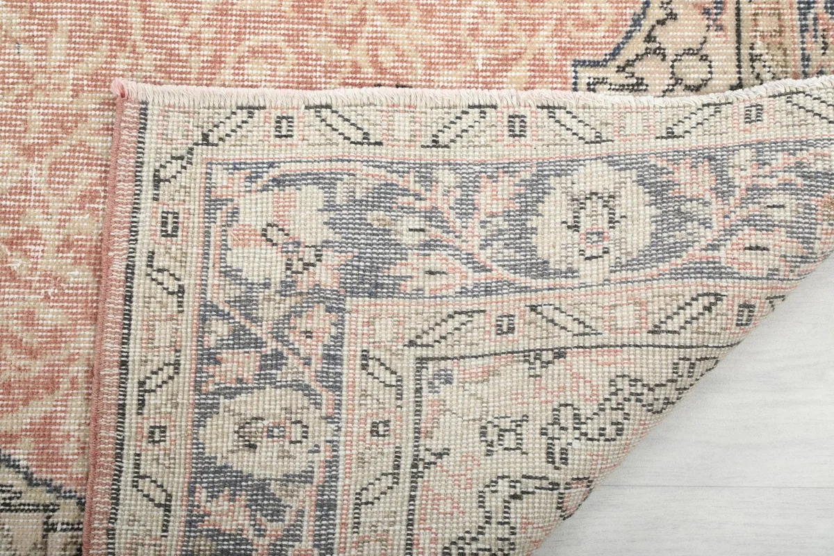 Close-up of the rug's reverse side, showing the hand-knotted cotton foundation and wool knots.