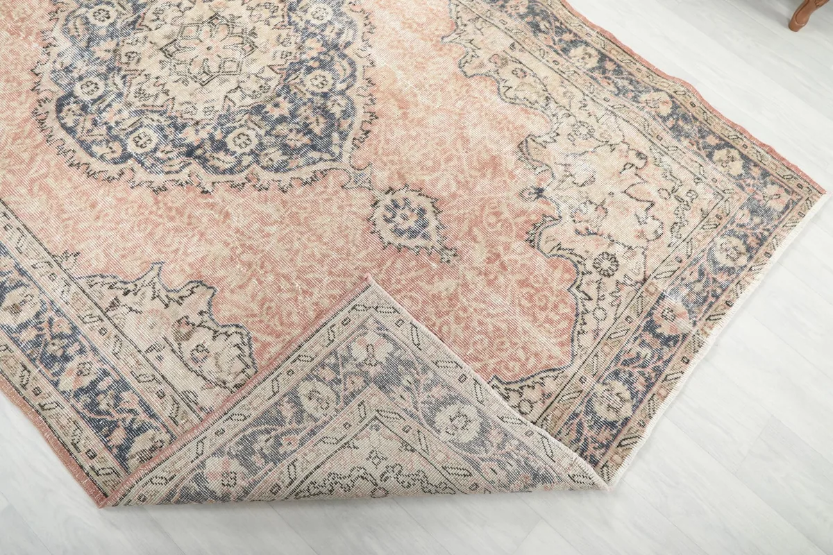 Folded corner of the rug, revealing the wool pile texture and the cotton foundation beneath.