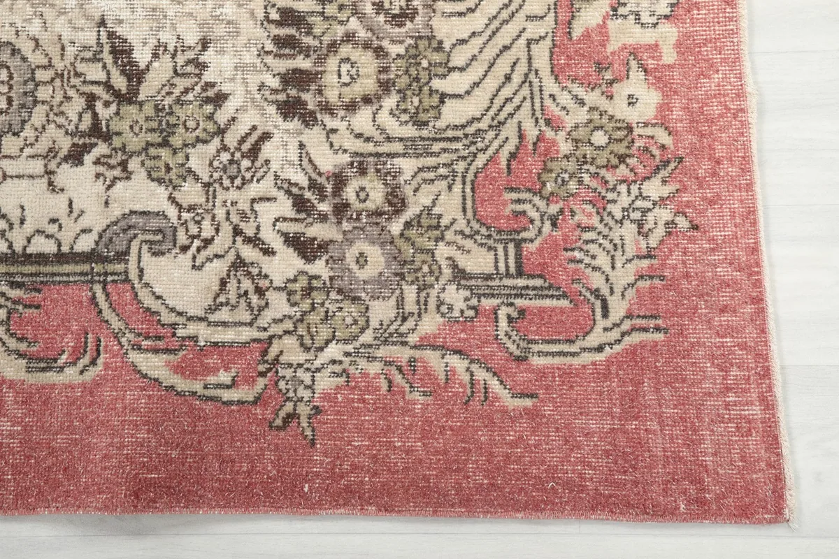 Detailed view of the rose border and the faded floral patterns on the rug