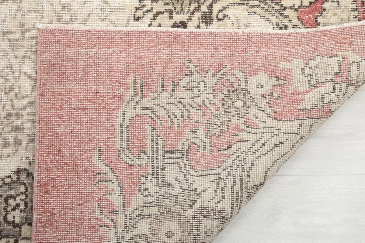 Close-up of the back of the rug where it is folded, showing the hand-knotted foundation