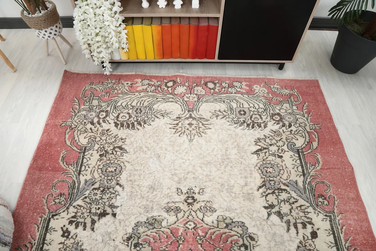 Overhead view focusing on the upper half of the rose and ivory rug's design