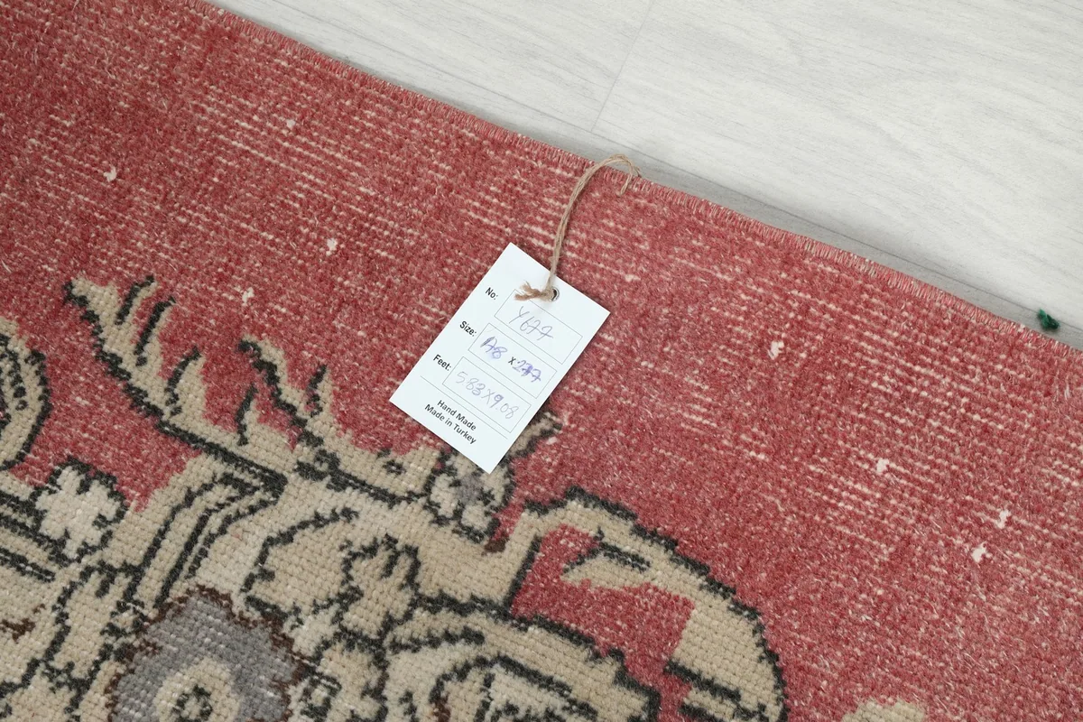 Product tag attached to the corner of the rose rug, displaying item information