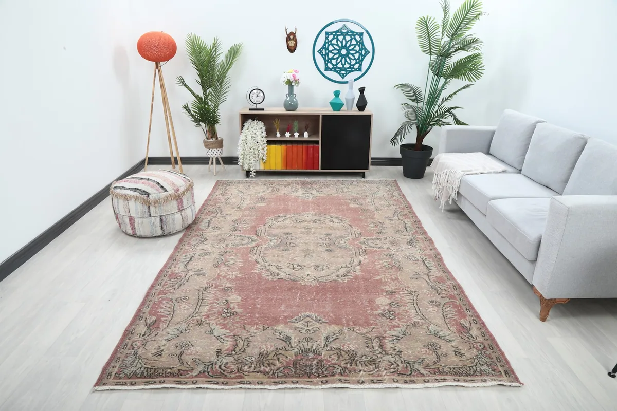 Vintage area rug with rose and beige tones in a contemporary living room setting