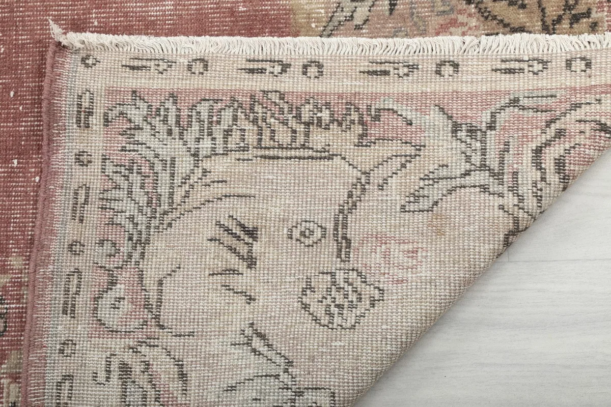 Close-up of the rug's reverse side and fringe, indicating its hand-knotted quality