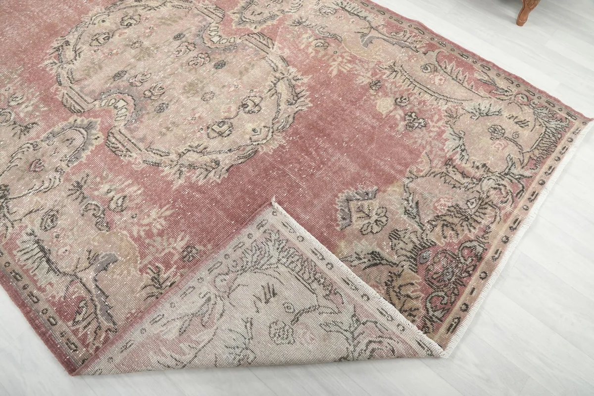 Corner of the rug folded back to reveal the back and the hand-knotted construction