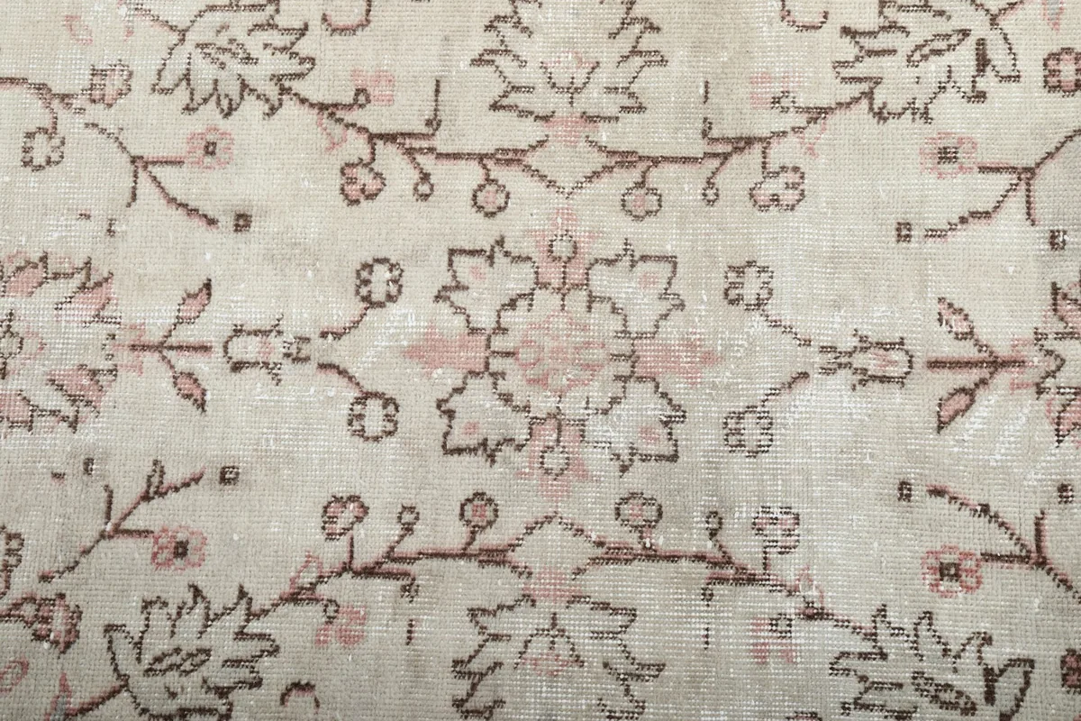 Close-up of the central floral motif and intricate vine patterns on the cream field