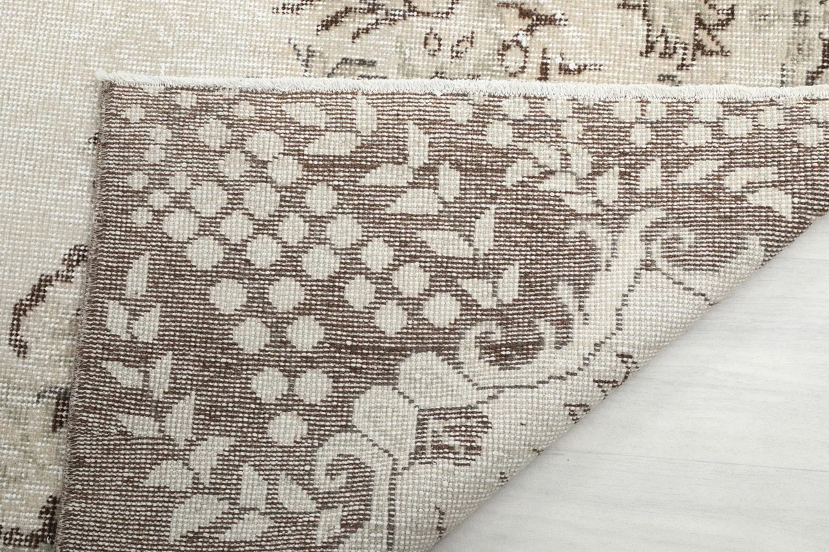 Close-up of the rug's back, showing the hand-knotted wool pile on cotton foundation