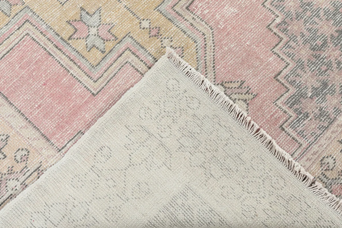 View of the back of the hand-knotted wool rug, revealing the cotton foundation and knotting