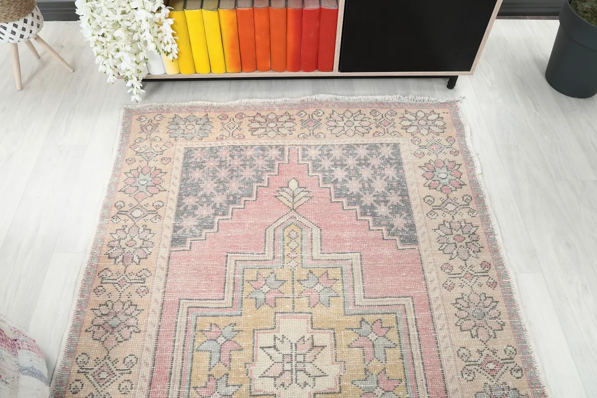 Overhead view of one end of the rug, showcasing the pink, gold, and gray patterns