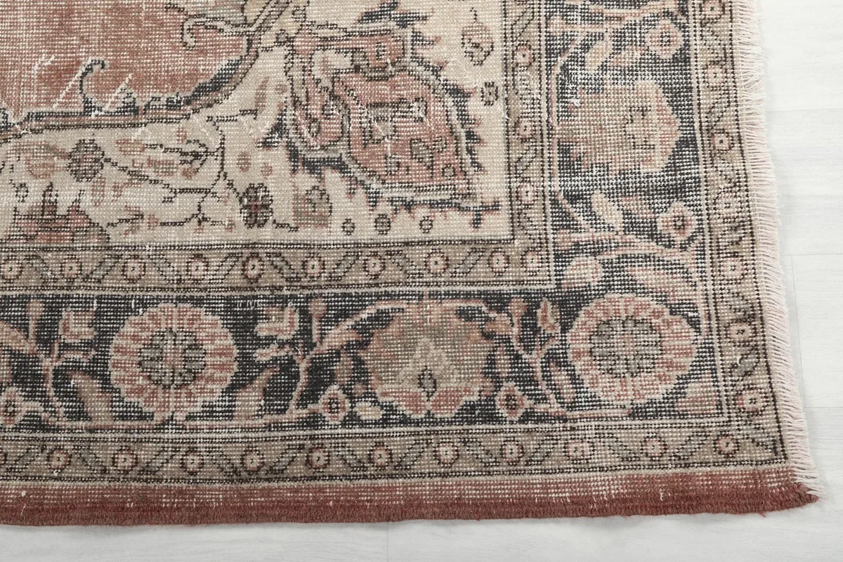 Detail of the charcoal and cream floral border with a rust edge on the vintage rug