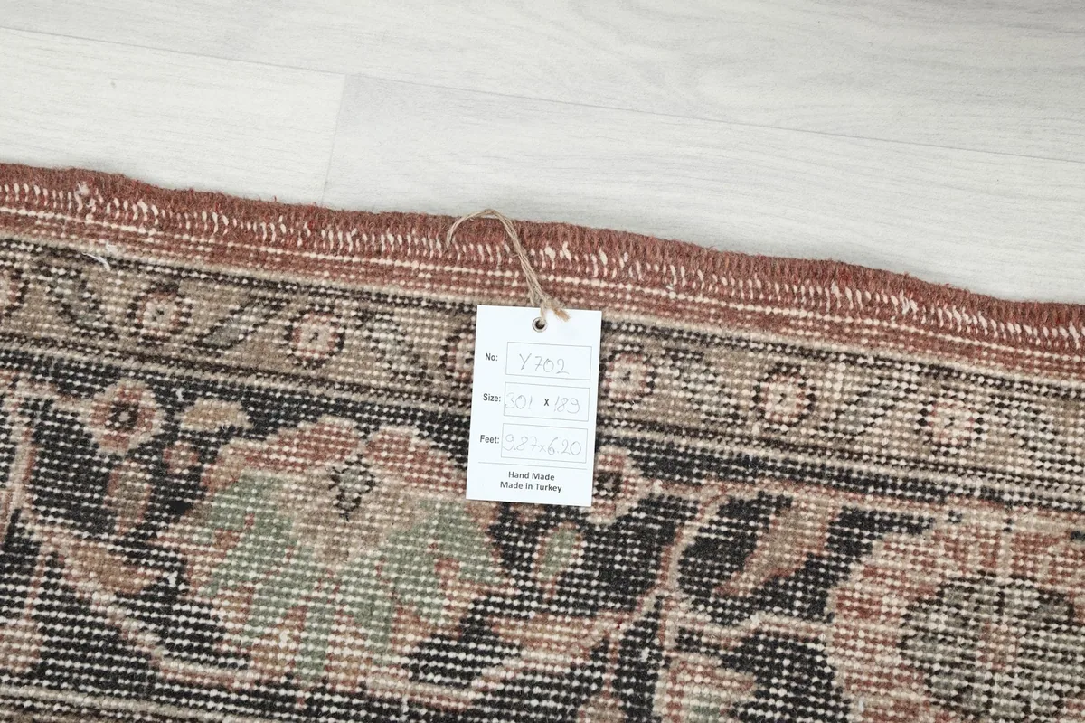 Detail of the rug with an attached tag showing its origin and hand-knotted nature