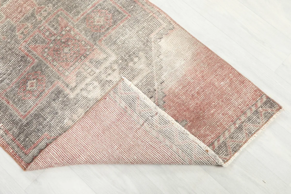 Folded corner of the runner rug, revealing the wool pile and cotton foundation