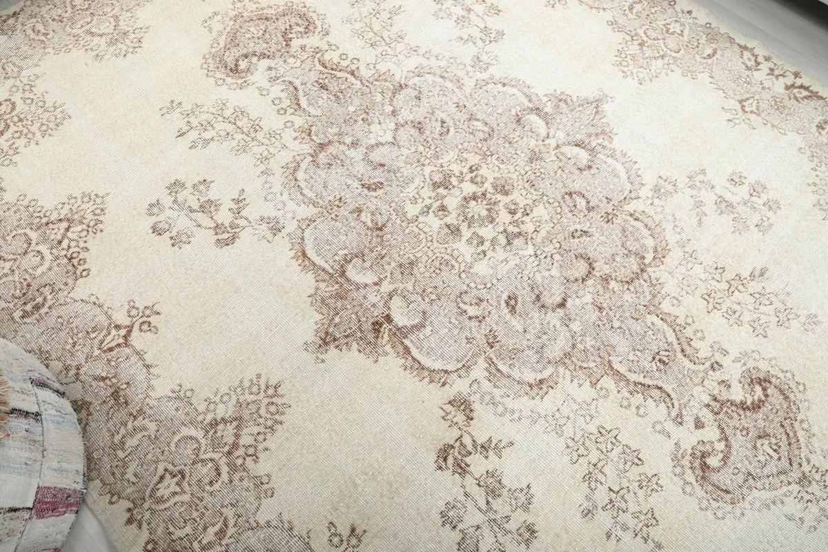 Overhead close-up of the central tan medallion and surrounding floral motifs