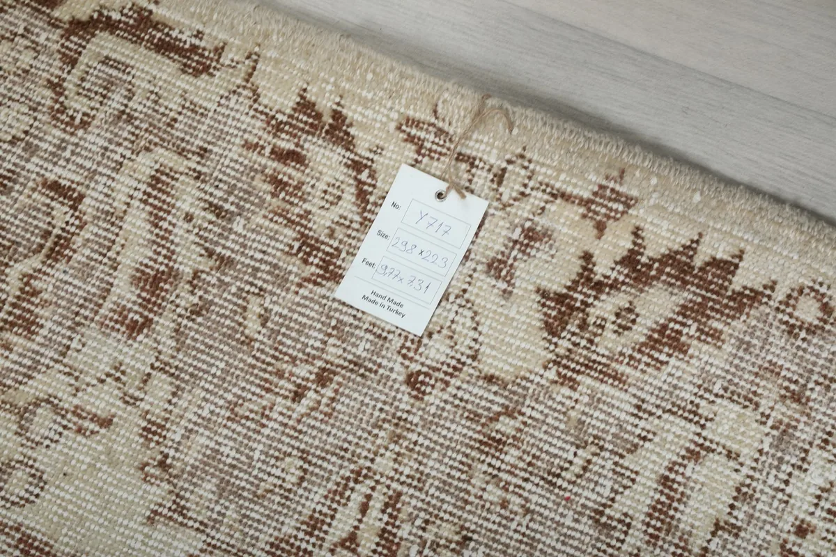 Close-up of the rug's edge showing the hand-knotted detail and product tag