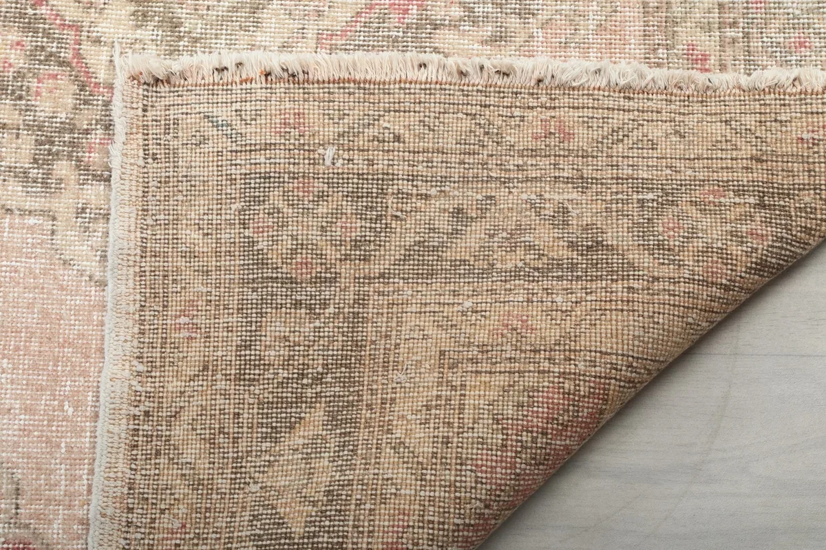 Close-up of the rug's reverse side, showing the cotton foundation and knotting