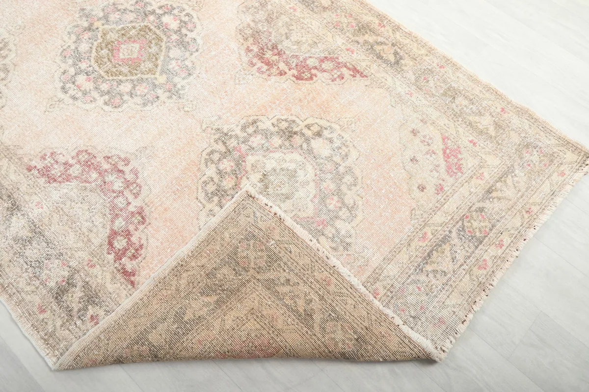 Folded corner of the rug revealing the backside and the hand-knotted construction