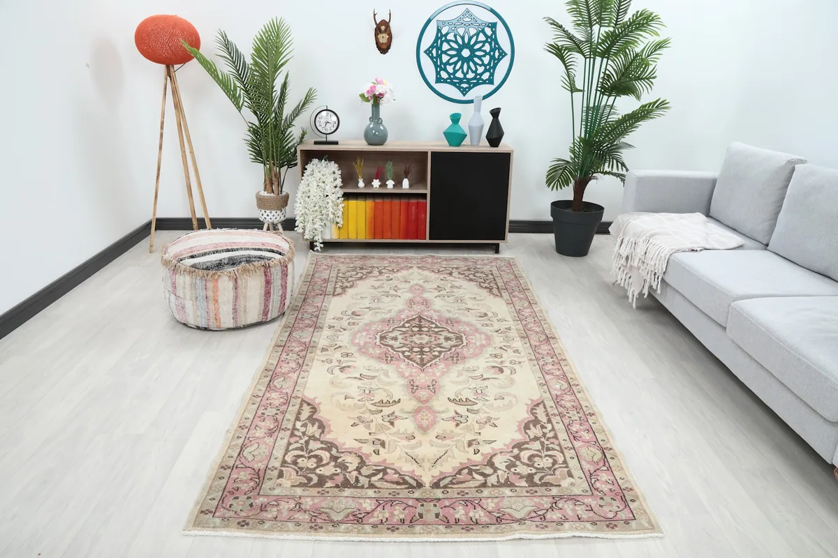 Vintage Anatolian rug displayed in a modern living room setting with a sofa and plants