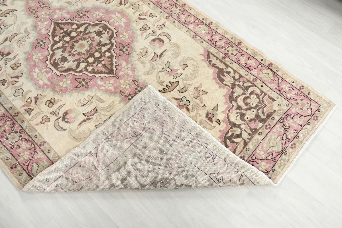 Corner of the rug folded back to reveal the cotton foundation and reverse side of the knots