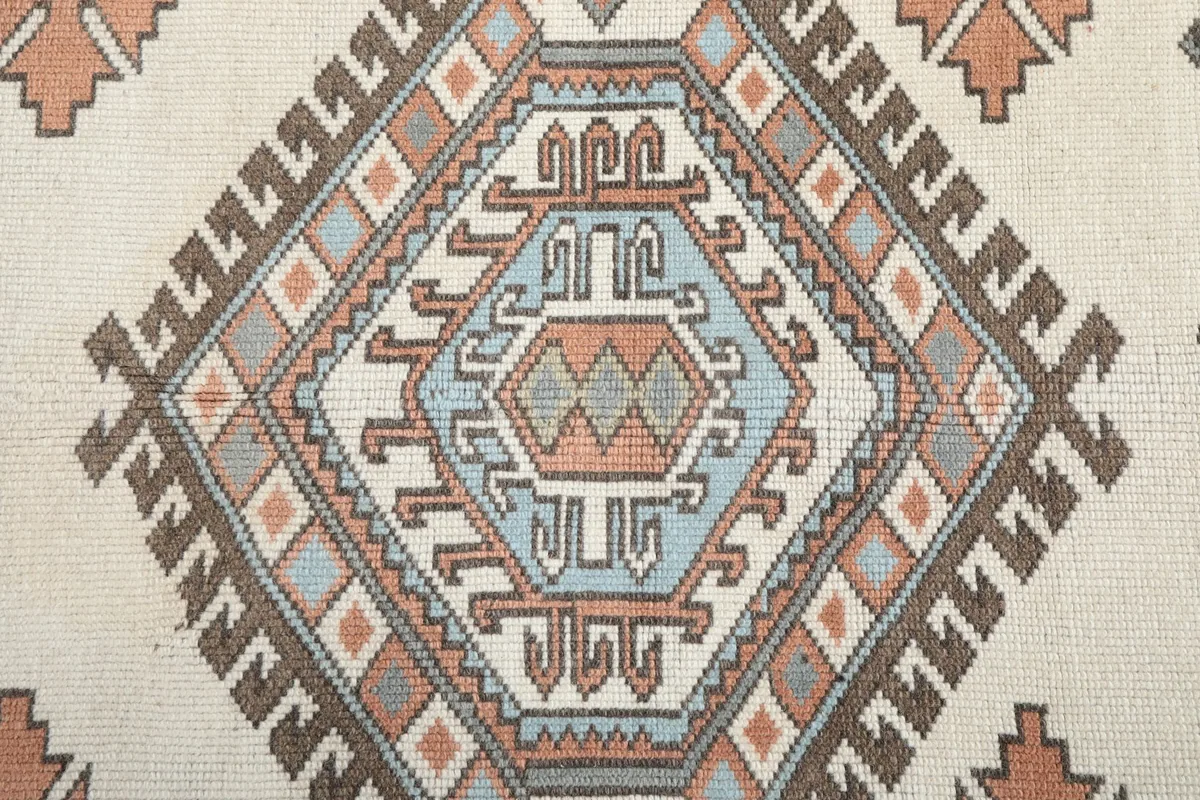 Close-up of a central geometric medallion with intricate blue, orange, and gray details.