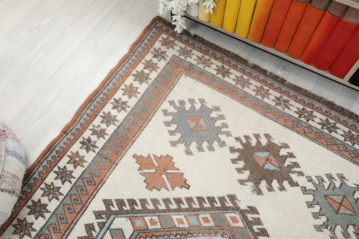 Detail of the rug's border design and fringe, showing the wool texture.