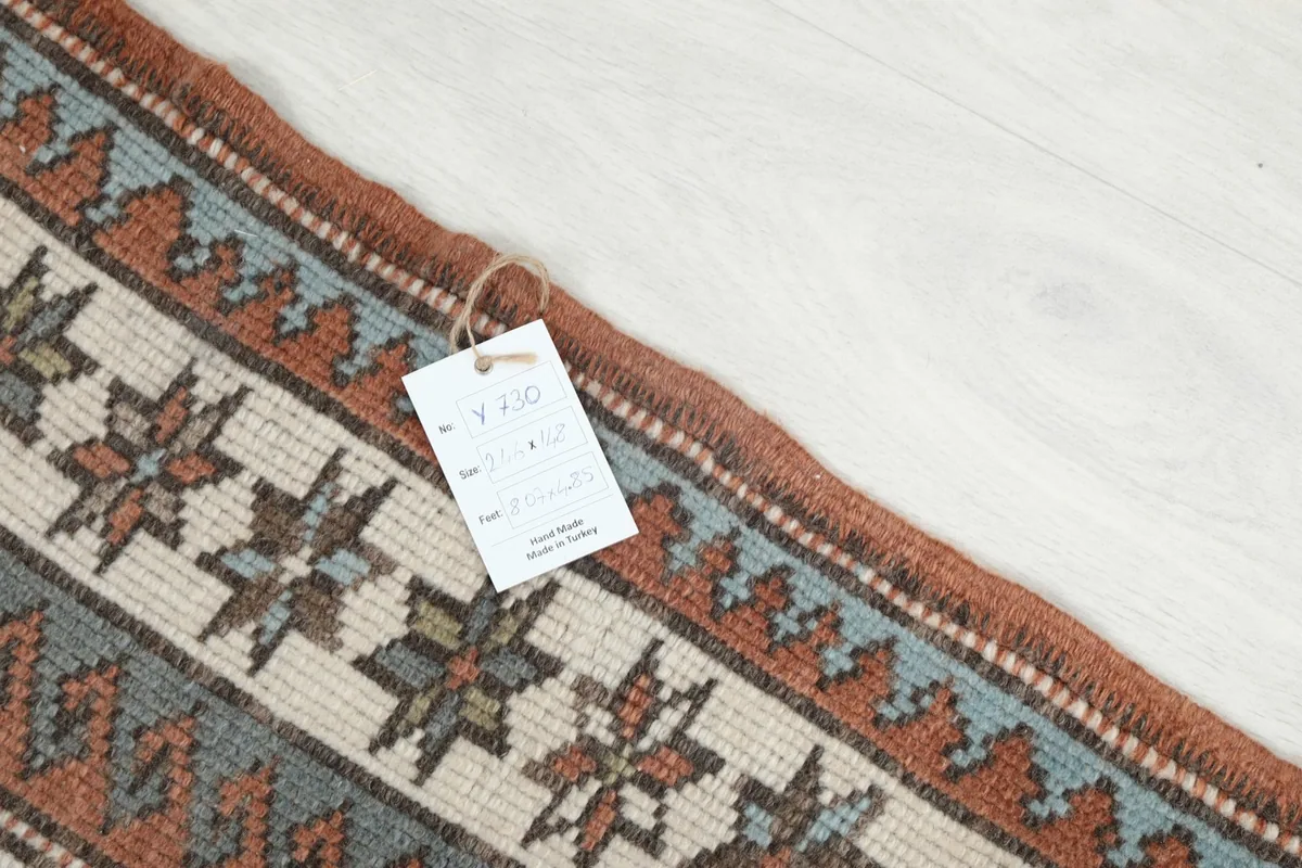 Close-up of the rug's border with a product tag, showing texture and colors.