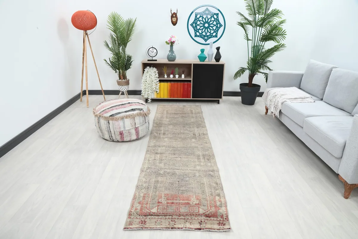 Vintage Anatolian runner rug in a modern living space, showing its full length from an angle.