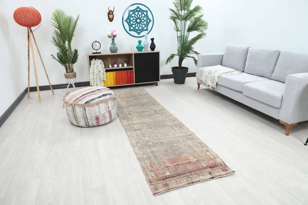 Runner rug in a room setting, highlighting its muted gray tones and distressed finish.