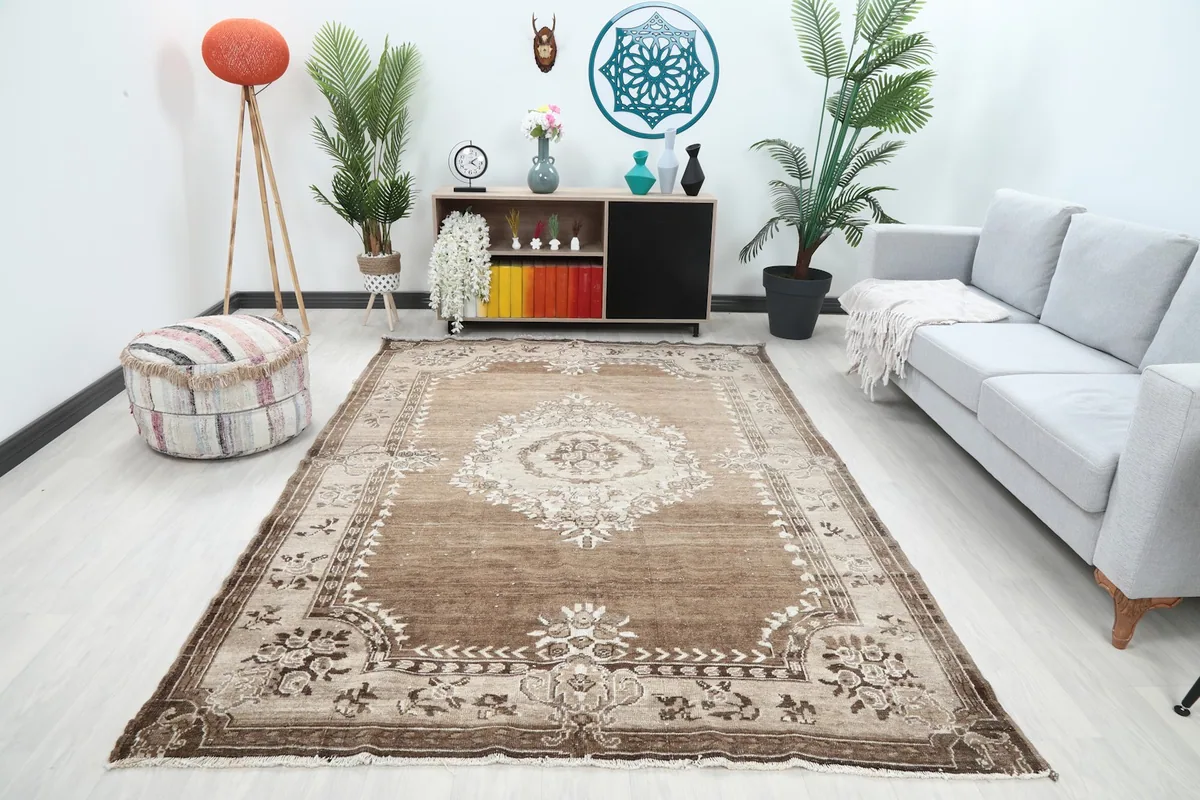 Vintage brown and beige rug displayed in a living room setting with a light sofa
