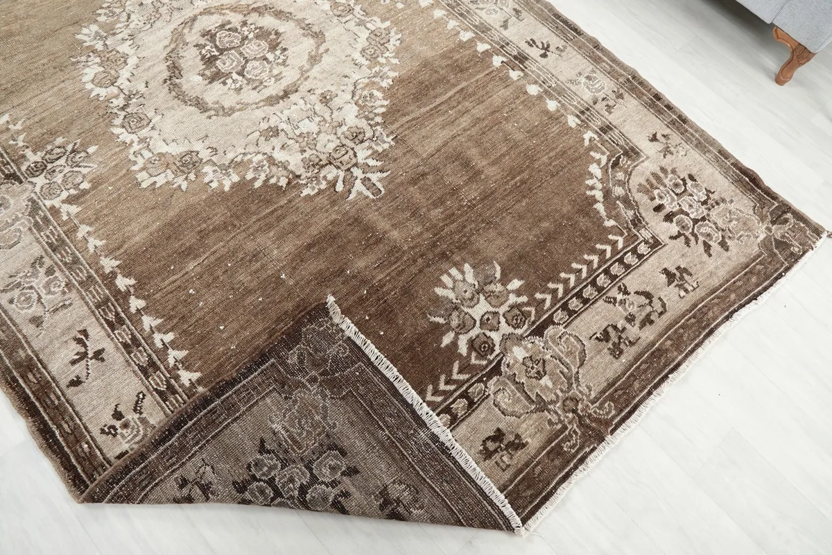 Corner of the rug folded back, revealing the cotton foundation and hand-knotted construction