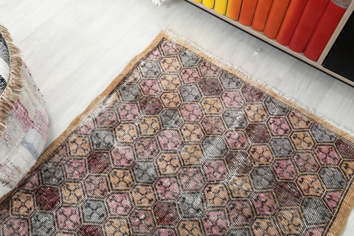 View of the rug's corner and edge, showing the fringed finish and the subtle tan border.