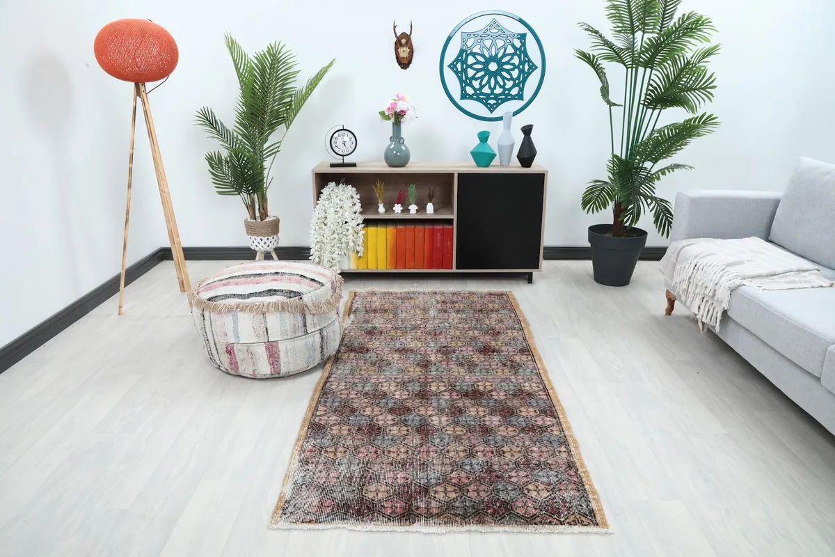Vintage Anatolian rug displayed in a bright living room setup with a gray sofa and modern decor.