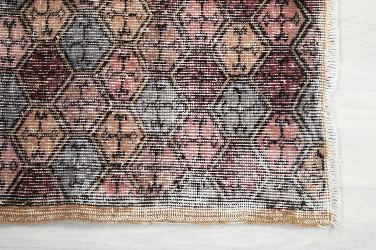 Detailed overhead shot capturing the intricate hexagonal geometric motifs and color variations of the rug.
