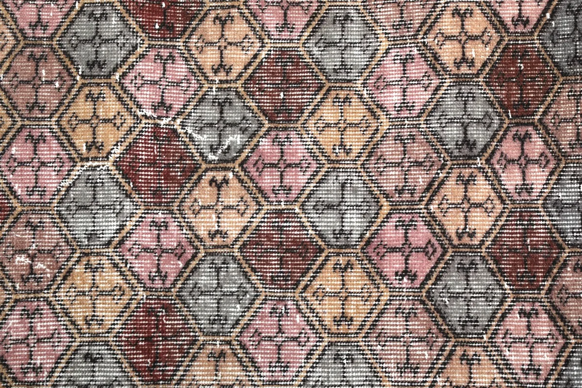 Extreme close-up of the hand-knotted wool pile, showing the distinct hexagonal shapes and color fading.