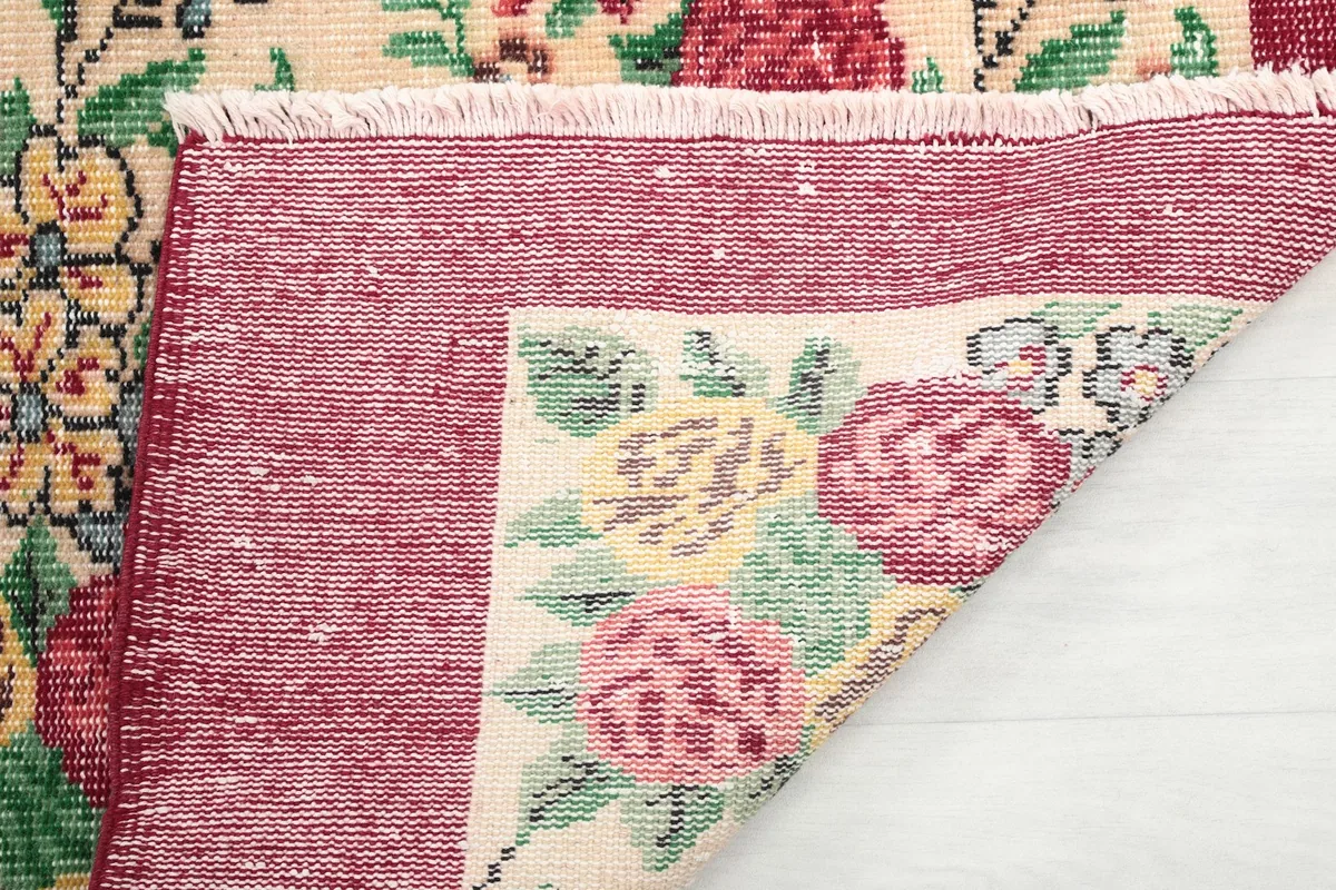 Close-up of the rug's back, showing the fringe and the tight weave of the cotton foundation.
