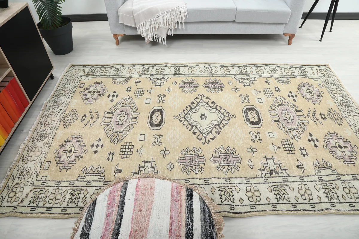 Beige Tribal Geometric Rug in a room, showing its scale with a sofa and pouf.