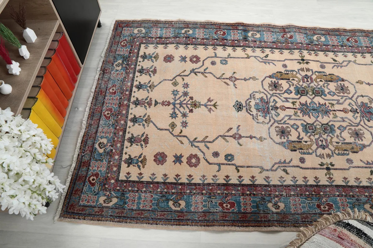 Side angle view of the cream and blue rug, highlighting its texture and design in a room