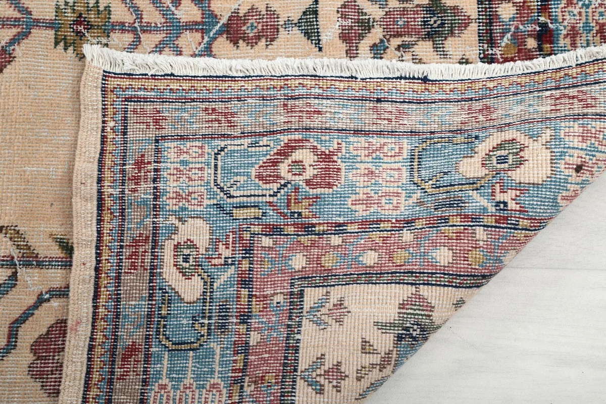 Underside view of the hand-knotted rug, showing the back of the border and fringe