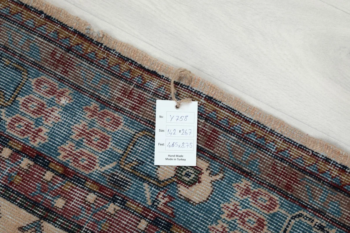 Close-up of the rug's edge with a tag showing size and origin details