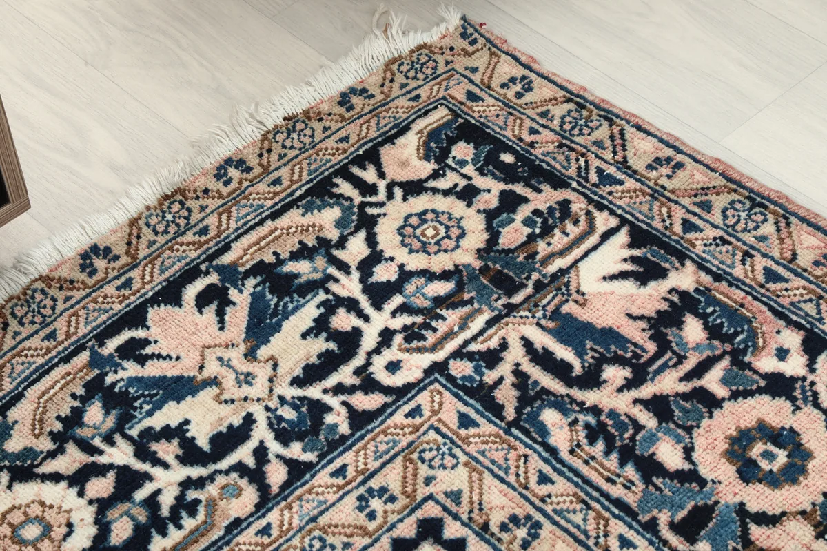 Detailed shot of the Rose Navy Floral Medallion Rug's border and fringe, highlighting the craftsmanship.