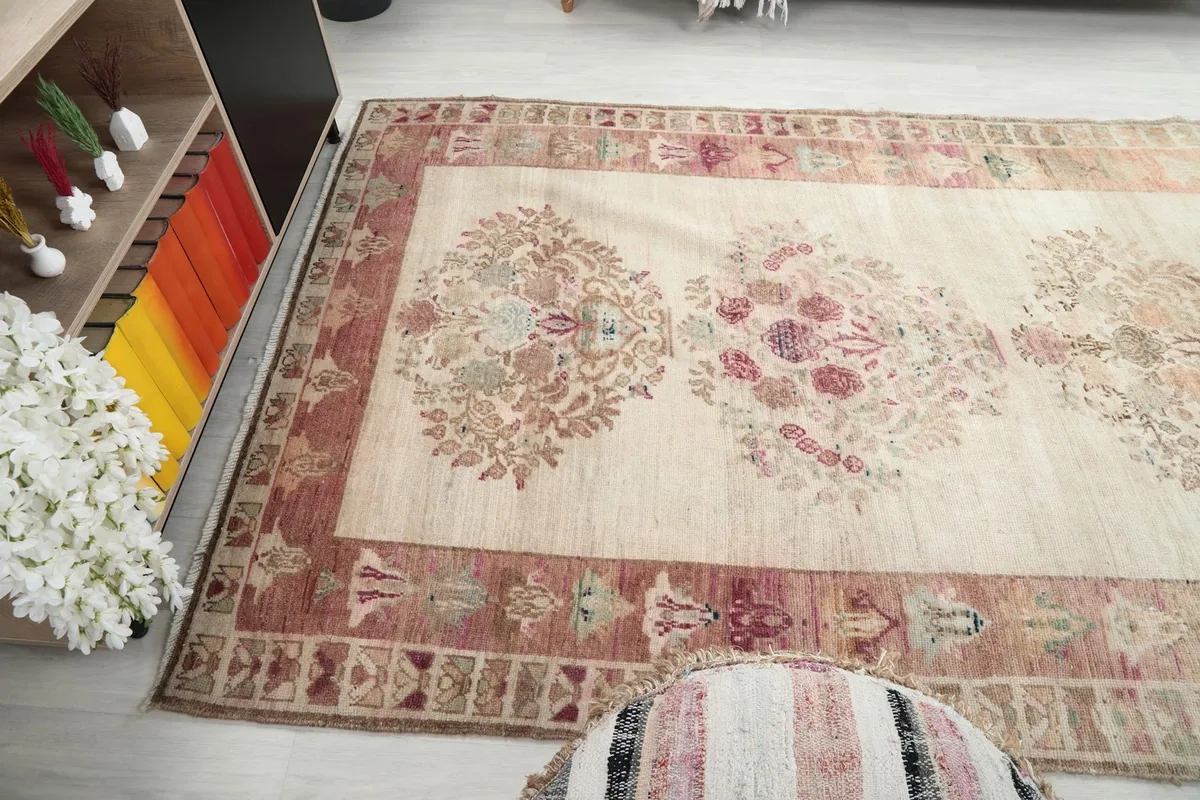 Wide angle view showing the full length of the rug's floral design and muted colors