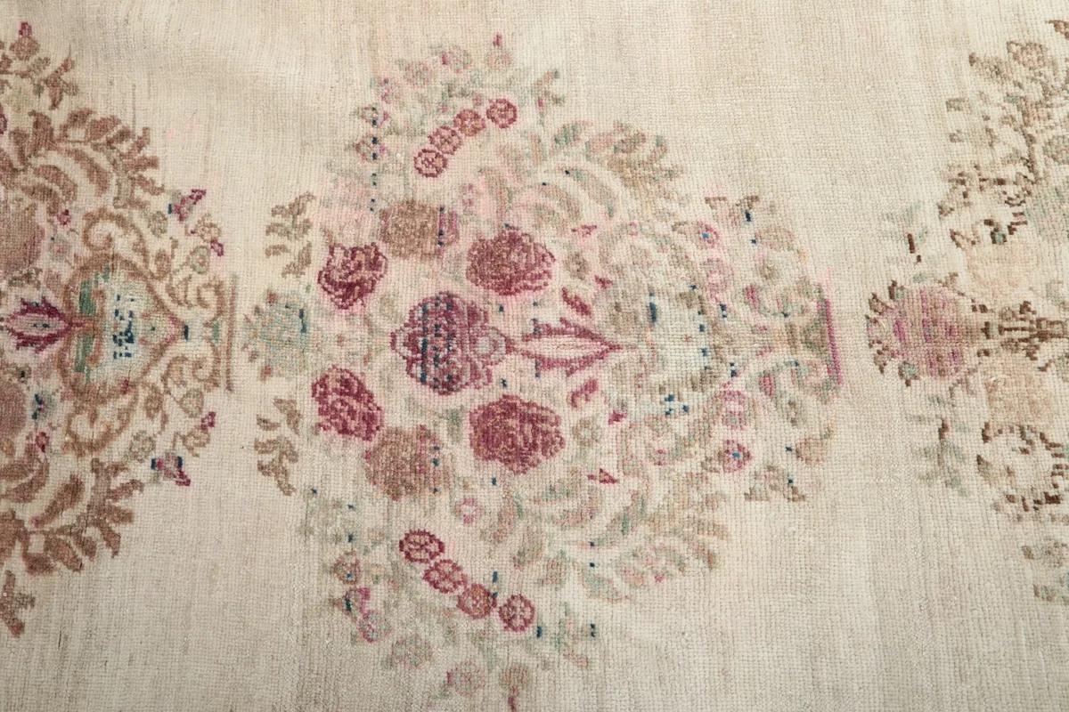 Close-up on the intricate rose and green floral patterns within the central medallion