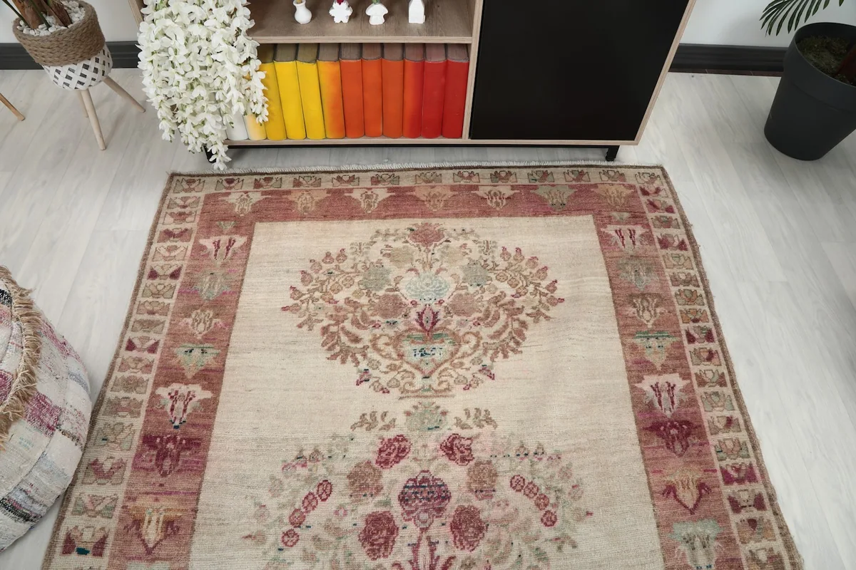 Overhead view of the ivory rug, highlighting the symmetrical floral medallions and border