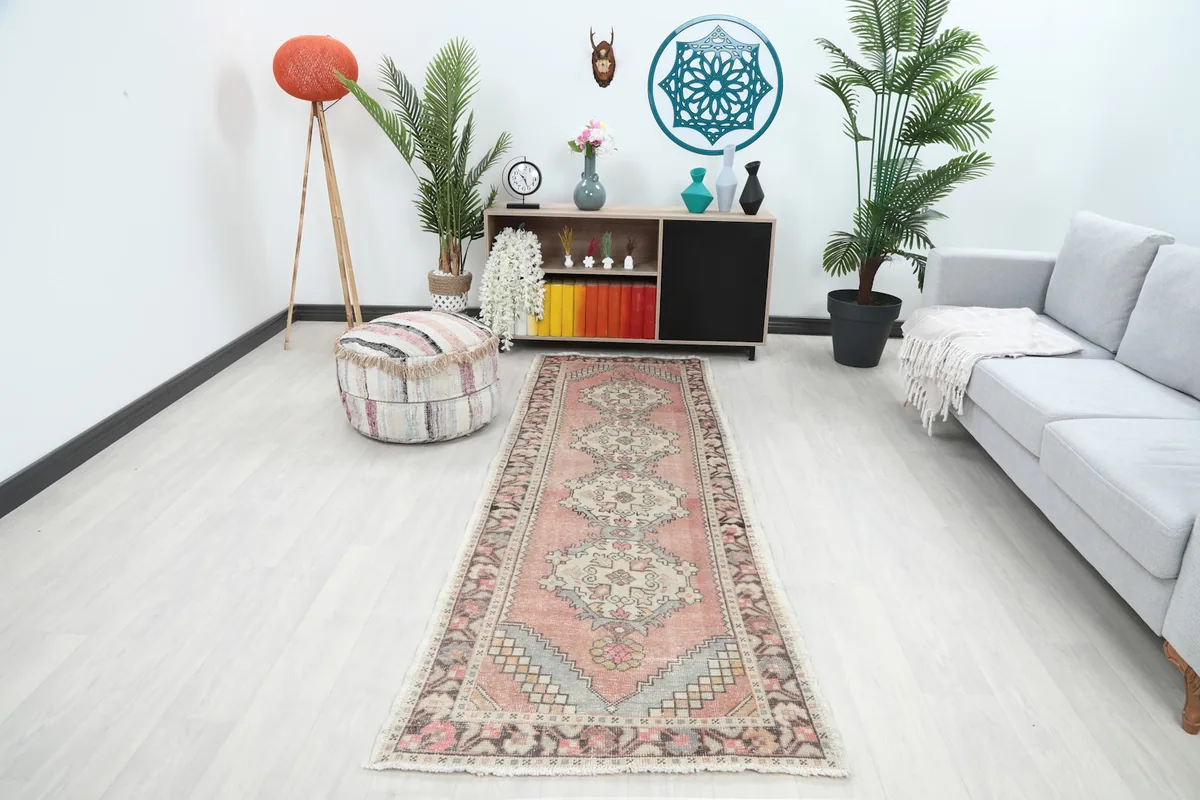 Runner rug displayed in a bright modern hallway with a light grey couch and wooden shelf