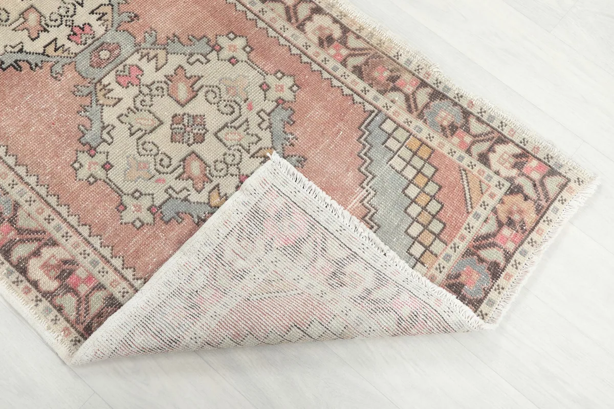 Corner of the rug folded to show the hand-knotted cotton foundation and reverse side