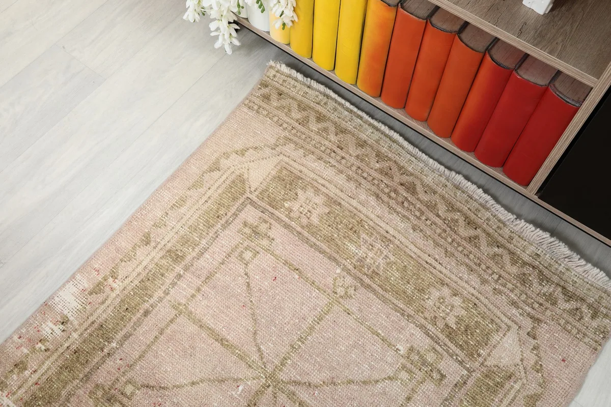 Corner of the runner showing the fringe and part of the geometric design, with colorful books in the background.