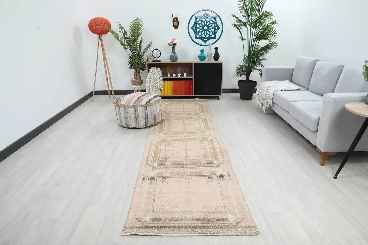 Vintage Anatolian runner in a living room setting, showcasing its length and pink and olive geometric patterns.