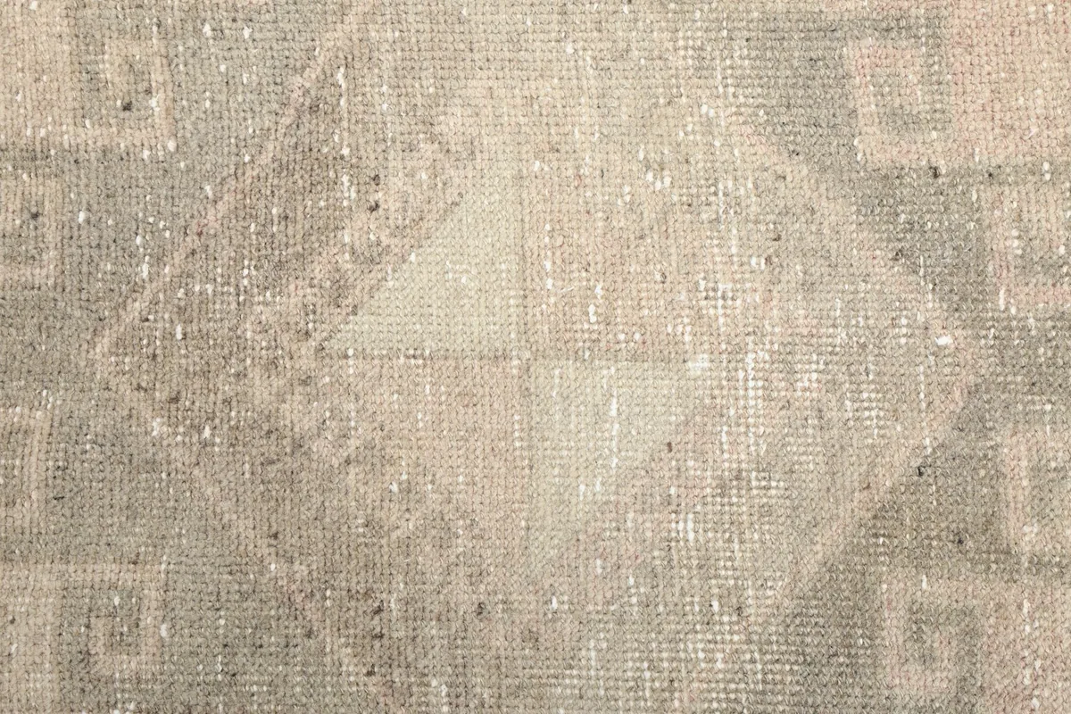 Texture of the low wool pile, showing the individual knots and the distressed appearance of the fibers.
